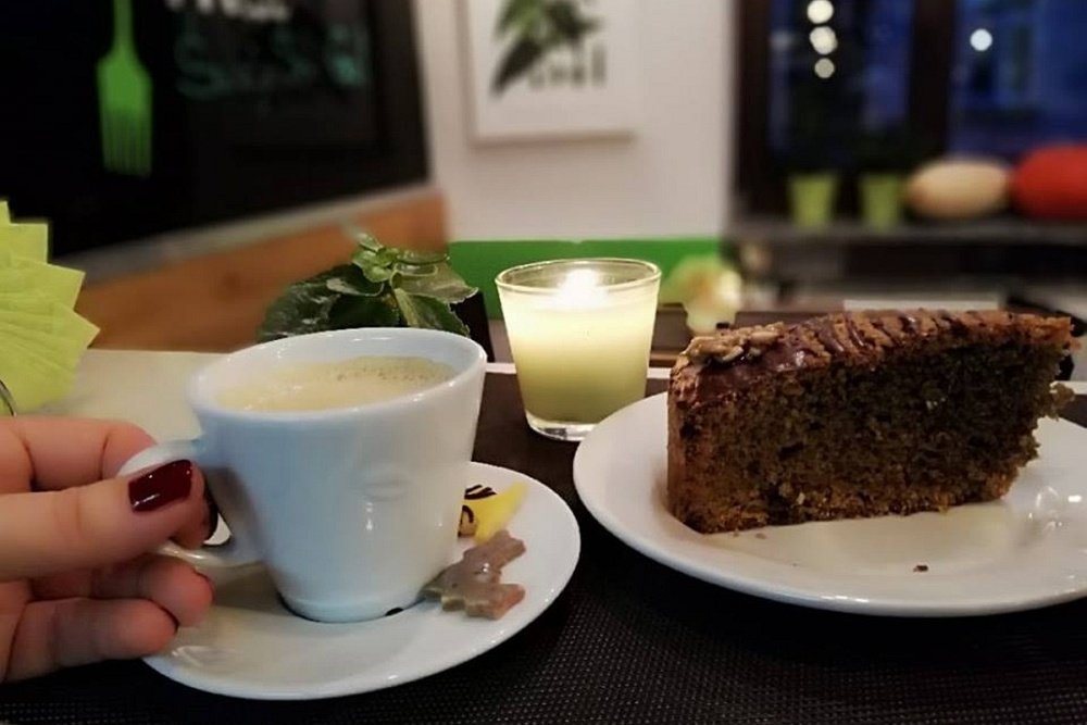 Zdjęcie przedstawia filiżankę kawy i porcję ciasta w restauracji Chwas Prast