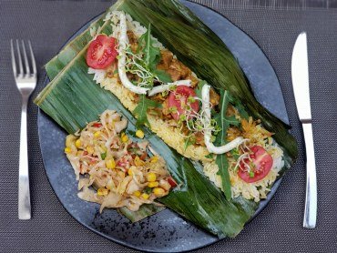 Na talerzu tempeh z duszonym po tajsku porem, grillowany w liściu bananowca podawany z ryżem i surówką