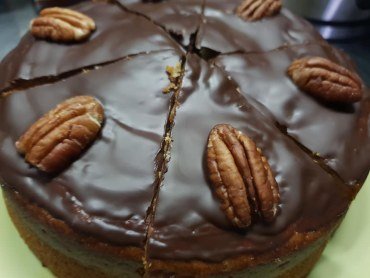 Zdjęcie przedstawia ciasto bananowe z orzechami pekan