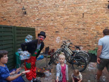 Zdjęcie przedstawia klauna Koko i dzieci na podwieczorku w Chwast Prast