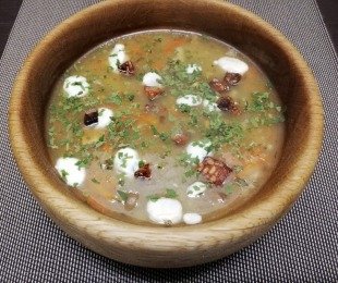 Zdjęcie przedstawia talerz żurku z wędzonym tempehem i vegańską kwaśną śmietaną