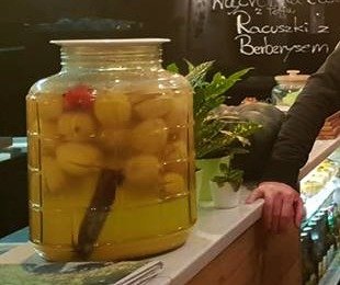 Zdjęcie przedstawia duży słój z kiszonymi cytrynami