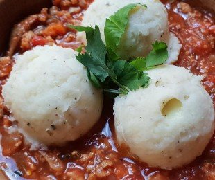 Na zdjęciu talerz, na nim potrawa Fufu z pochrzynu podane z gulaszem