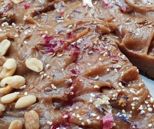 Zdjęcie przedstawia ciasto arachidowo bananowe udekorowane orzechami arachidowymi