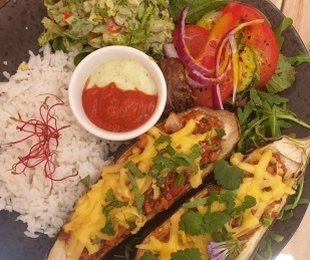 Na zdjęciu talerz, na nim Bakłażan zapiekany z wege mięskiem podany z ryżem, warzywami i sosami