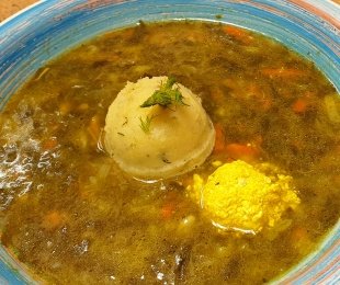 Zdjęcie przedstawia talerz zupy szczawiowej z vegańskim żółtkiem, śmietaną i pure ziemniacznym