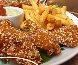 Zdjęcie przedstawia potrawę Skrzydełka z boczniaka z frytkami, warzywami i sosami