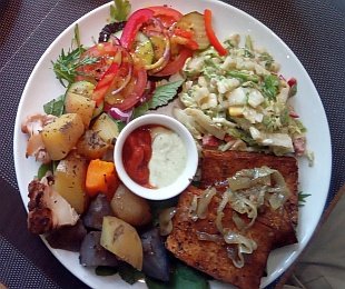 Zdjęcie przedstawia Polędwiczki sojowe podane z pieczonymi ziemniakami, surówką, warzywami i sosami